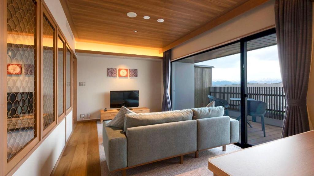 un salon avec un canapé et une télévision dans l'établissement Hotel Shion, à Morioka