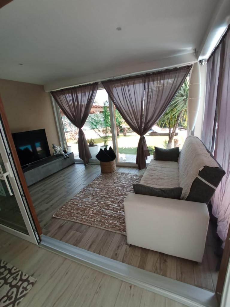 un salon avec un canapé blanc et une télévision dans l'établissement villa relax, à Riva del Garda