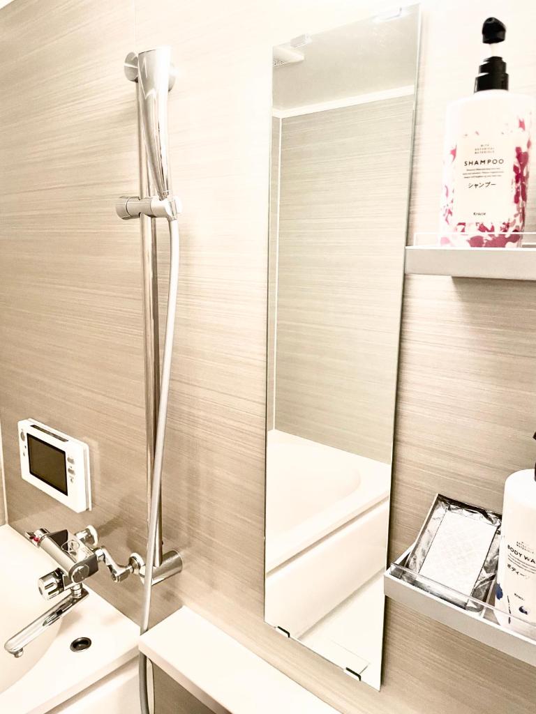 une salle de bain avec un miroir à côté d'un lavabo dans l'établissement Hotel BIX チェックイン23時 変更不可, à Tokyo 14 autres photos