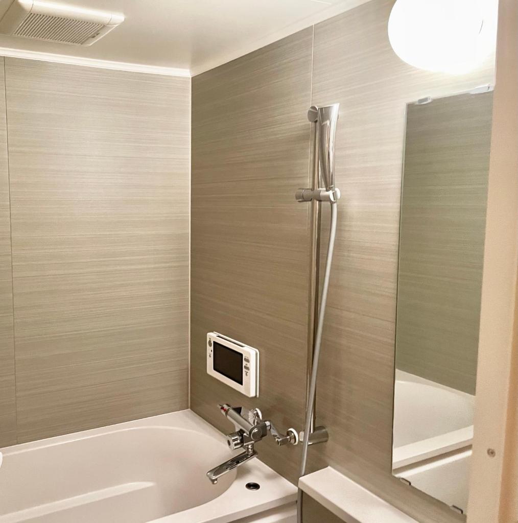 une salle de bain avec une baignoire, un lavabo et une douche dans l'établissement Hotel BIX チェックイン23時 変更不可, à Tokyo