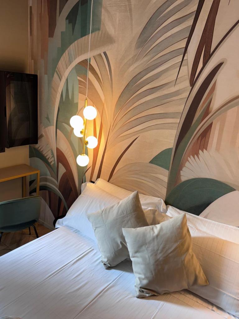 une chambre d'hôtel avec un lit orné d'une peinture murale. dans l'établissement Rock Crystal Boutique Hotel, à Gabicce Mare