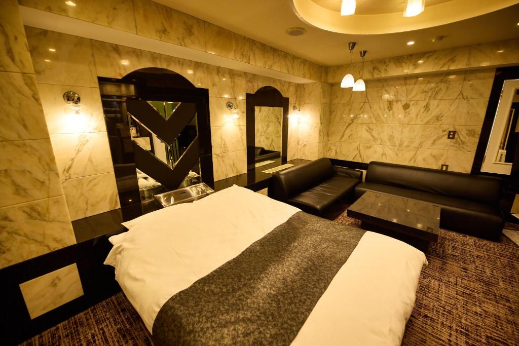 une chambre d'hôtel avec un lit et un canapé dans l'établissement Hotel Piatt (Adult Only), à Nagoya