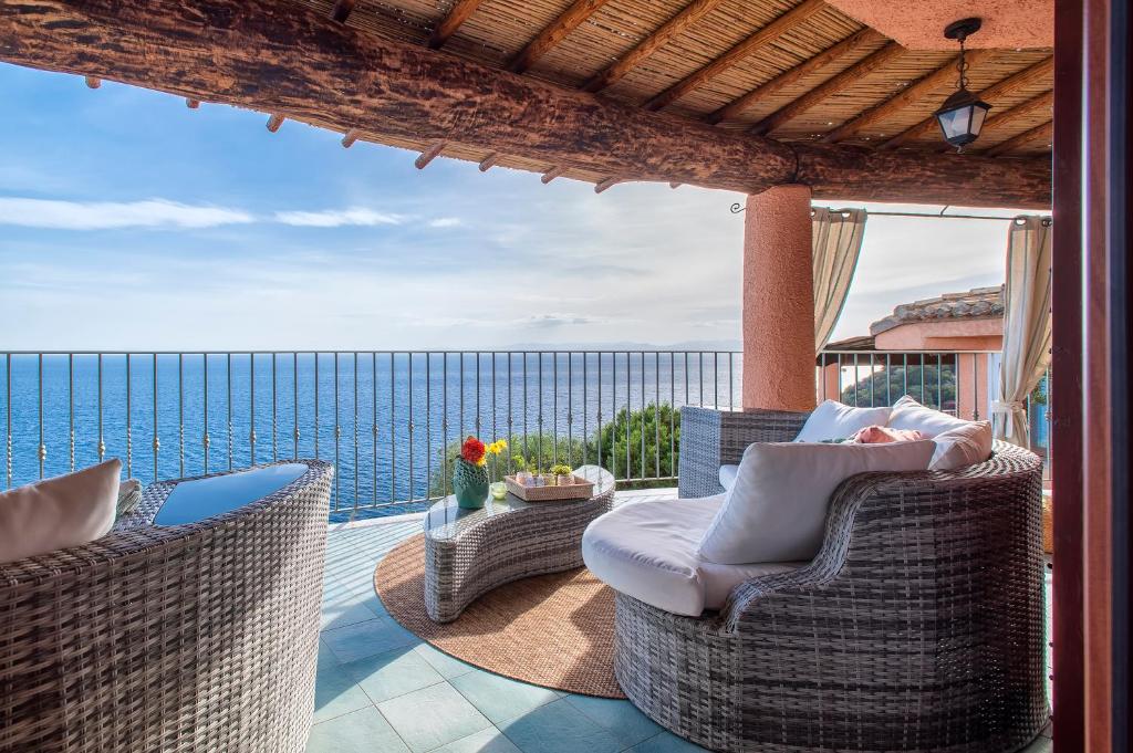 un patio avec des chaises et une vue sur l'océan dans l'établissement Villa Gemma Torre delle Stelle Coast with infinity pool panoramic terraces and garden, à Torre delle Stelle