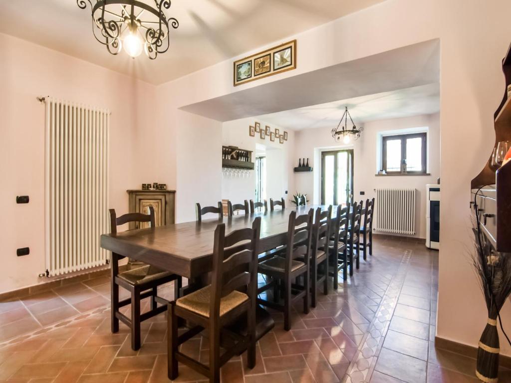 une salle à manger avec une longue table et des chaises dans l'établissement Villa in Tavoleto with pool, à Tavoleto
