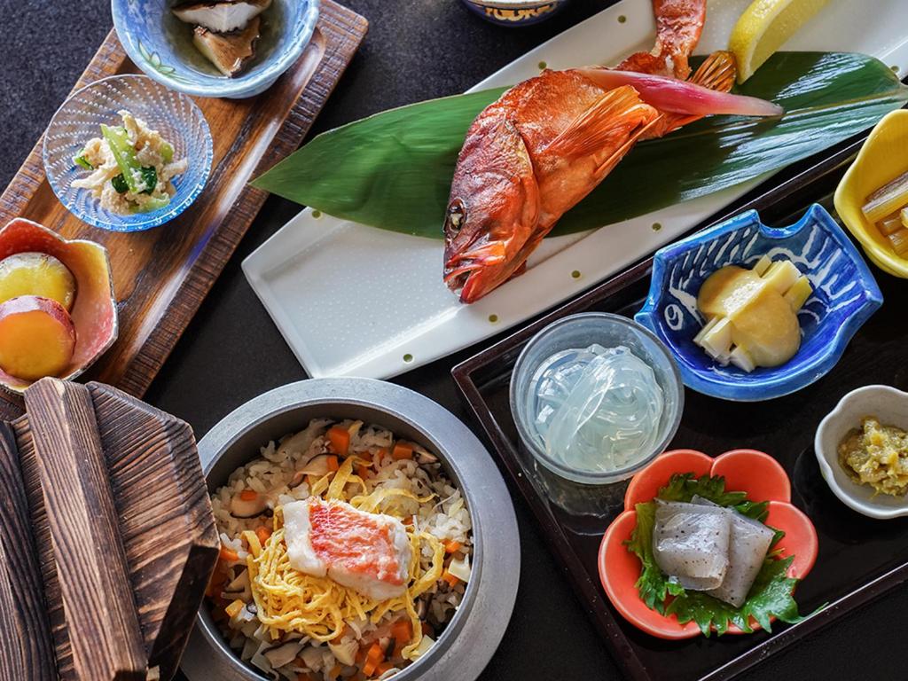 une table garnie de plats de nourriture avec du poisson et du riz dans l'établissement IZU RETREAT by Onko Chishin, à Higashiizu