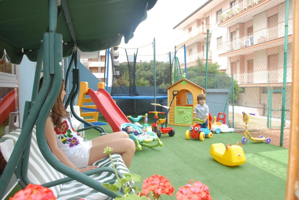 une femme et un enfant jouant dans une aire de jeux dans l'établissement Hotel President, à San Benedetto del Tronto