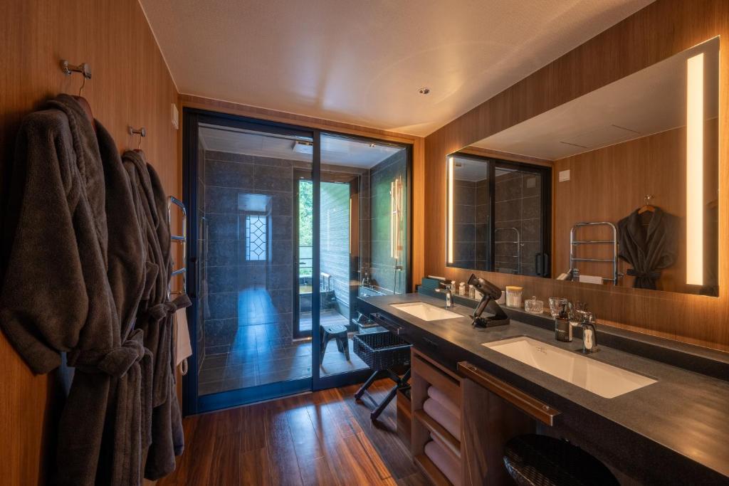 une salle de bain avec deux lavabos et un grand miroir dans l'établissement THE YUKAWA Ichijoh Branch, à Shiroishi