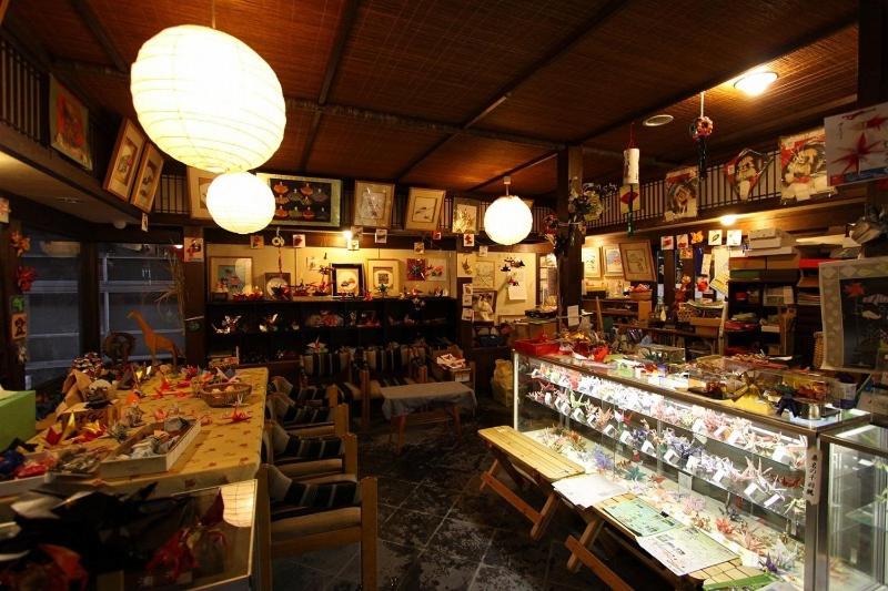 d'une pièce avec un magasin doté de tables, de chaises et de lumières. dans l'établissement Onyado Hishiya Torazo, à Yamanouchi