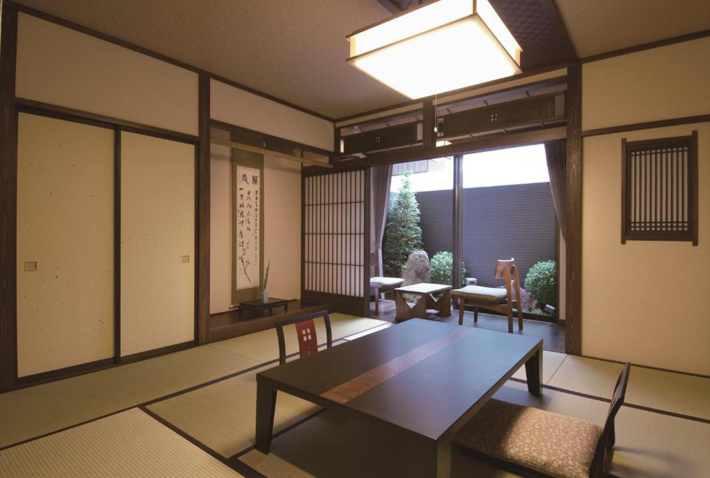 un salon avec une table et une grande fenêtre dans l'établissement Ryokan Tanabe 旅館田邊, à Takayama