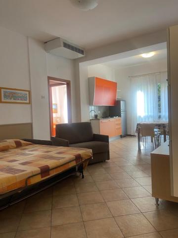 un salon avec un lit et une salle à manger dans l'établissement Aparthotel Gioia, à Caorle
