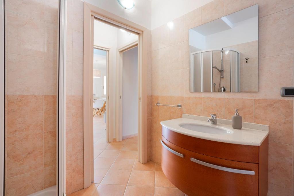 une salle de bain avec un lavabo, un miroir et une douche dans l'établissement Villa Lolly, à Quartu SantʼElena 34 autres photos