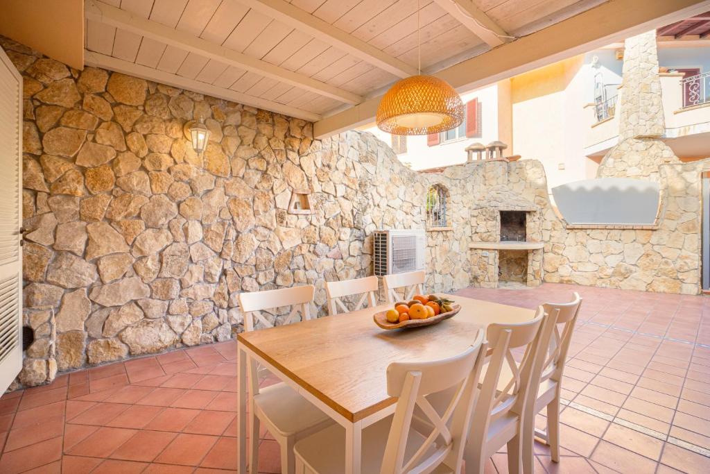 une salle à manger avec une table et un mur en pierre dans l'établissement Villa Lolly, à Quartu SantʼElena