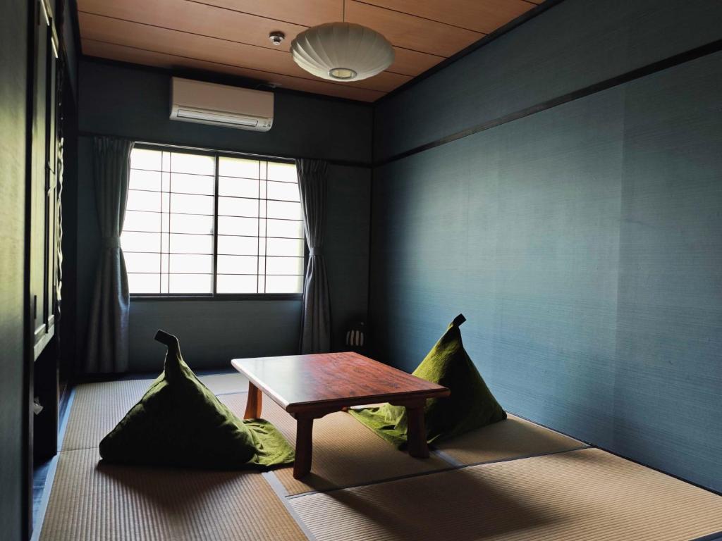 une pièce avec une table et deux oreillers verts dans l'établissement 層雲峡温泉 ホテル雲井, à Kamikawa 104 autres photos