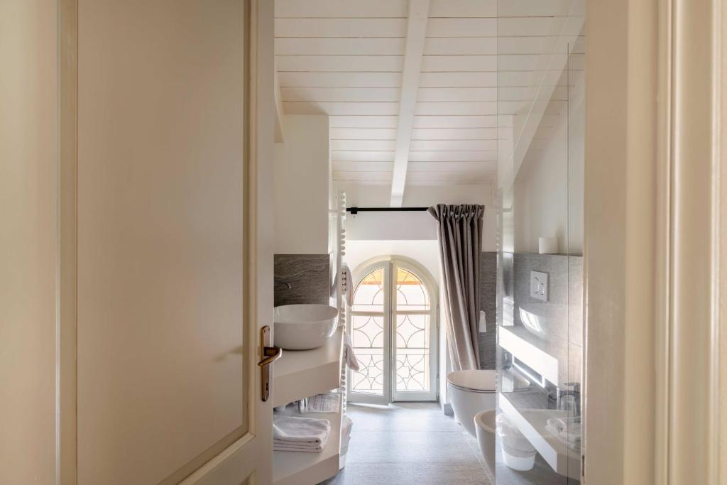 La salle de bains est pourvue de murs blancs et d'un plafond blanc. dans l'établissement Residence Ortensia, à Baveno 98 autres photos