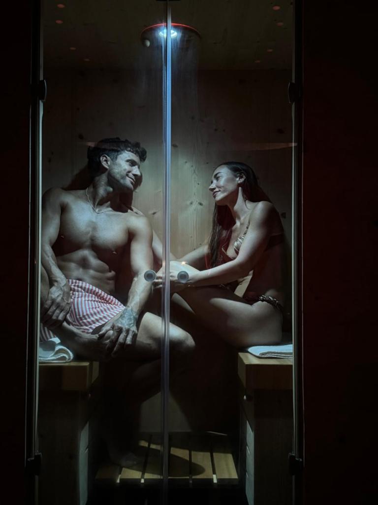 un homme et une femme assis dans une vitrine dans l'établissement Hotel Al Lago, à Lavarone