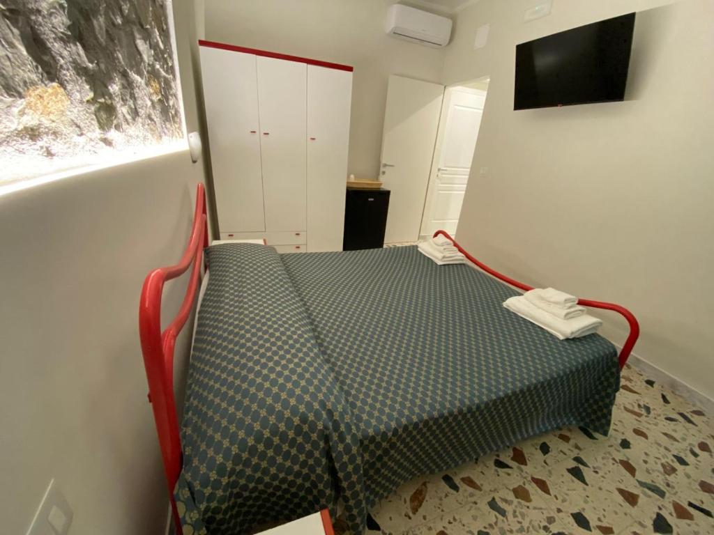 un petit lit dans une chambre avec une fenêtre dans l'établissement Cinquestelle Albergo del centro storico, à Palinuro