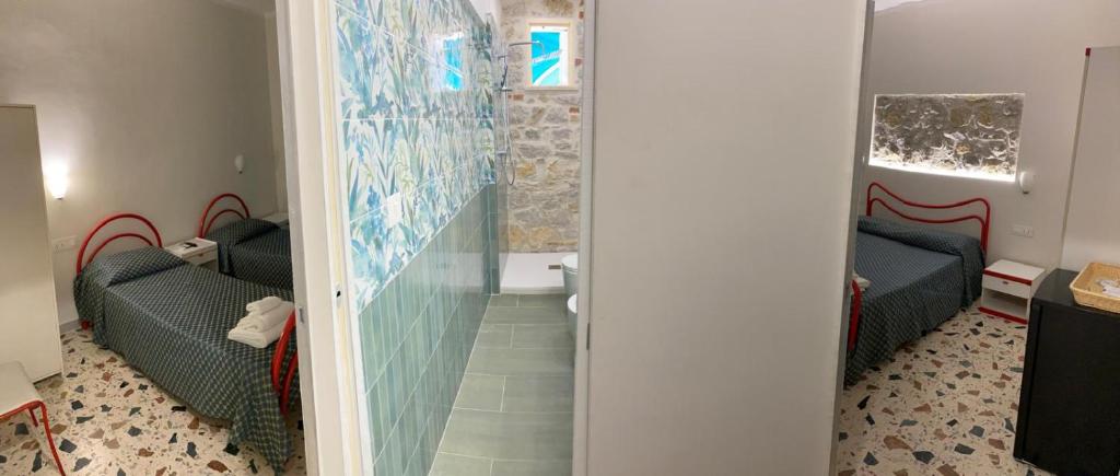 une chambre avec deux chaises et une douche à l'italienne dans l'établissement Cinquestelle Albergo del centro storico, à Palinuro