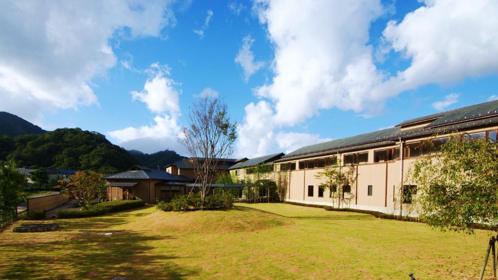 un bâtiment avec une cour d'herbe devant lui dans l'établissement Ginka, à Toyooka