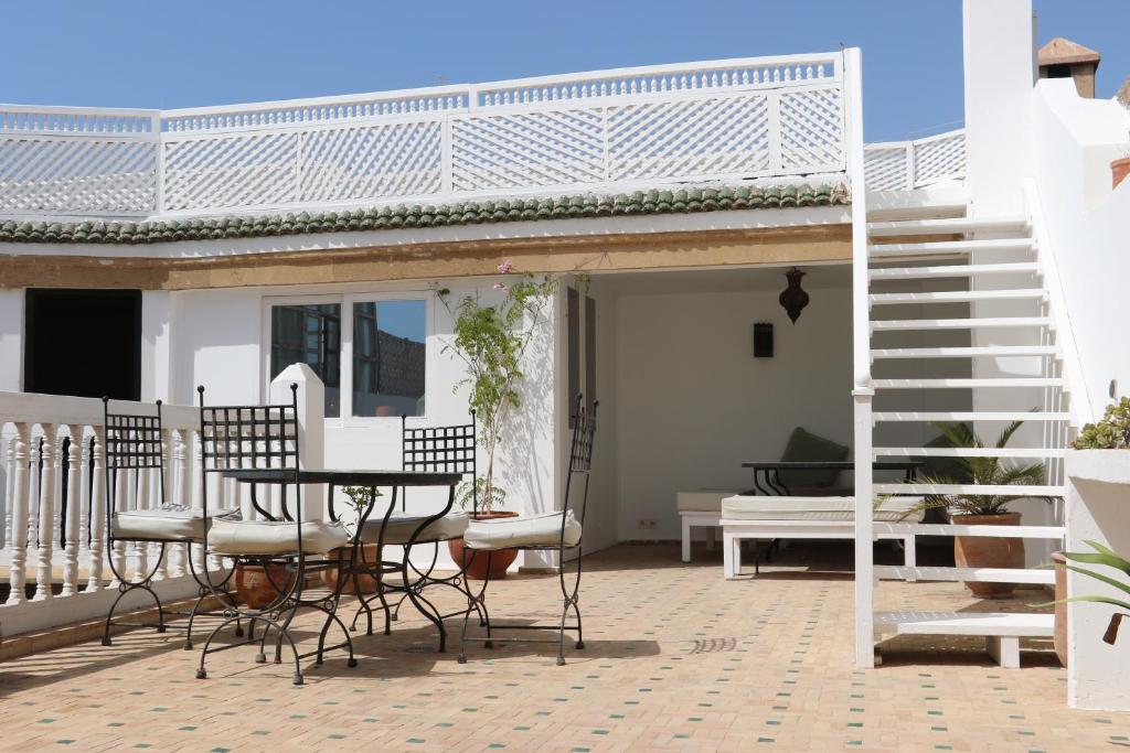une terrasse avec une table et des chaises dans une maison dans l'établissement RIAD DAR ASSALAMA Terrasse Vue Mer, à Essaouira 37 autres photos