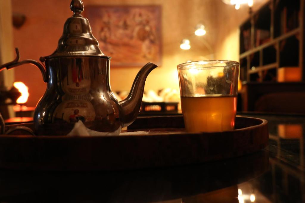 une bouilloire et un verre de bière sur une table dans l'établissement RIAD DAR ASSALAMA Terrasse Vue Mer, à Essaouira
