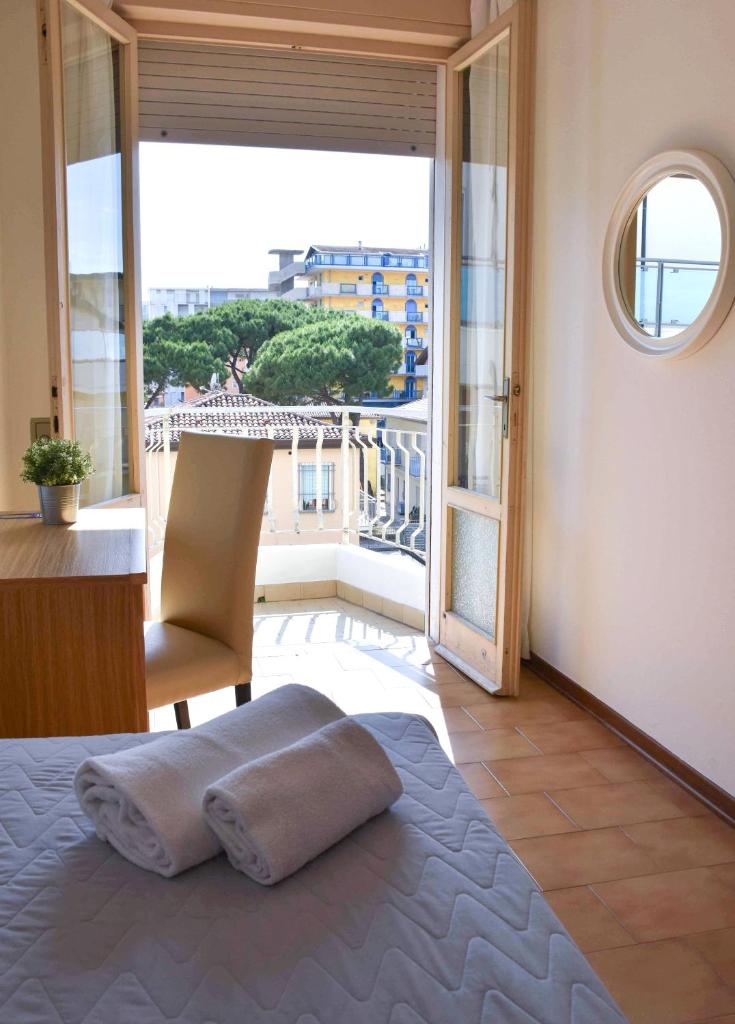 une chambre avec un lit et une grande fenêtre dans l'établissement Hotel Umberto, à Lido di Jesolo