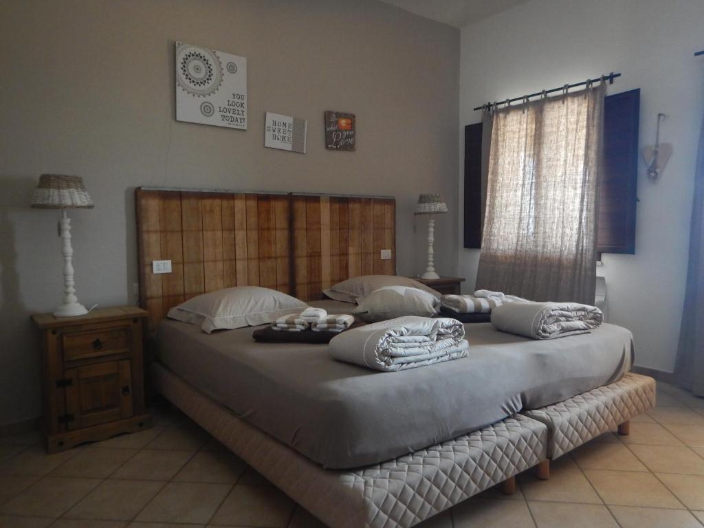 une chambre avec un grand lit avec des oreillers dessus dans l'établissement La Mariachiara, à Tertenìa 50 autres photos