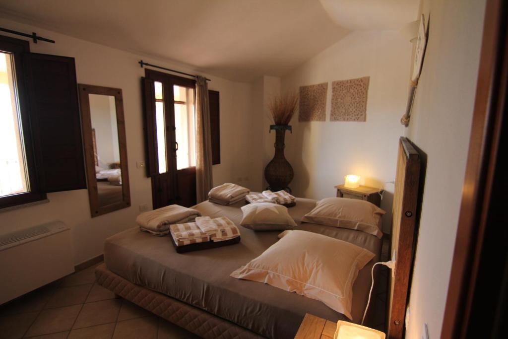 une chambre avec un grand lit avec des oreillers dessus dans l'établissement La Mariachiara, à Tertenìa