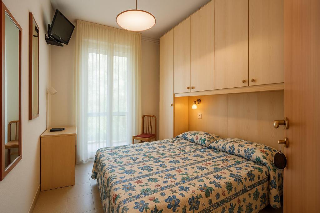 une chambre d'hôtel avec un lit et une fenêtre dans l'établissement Hotel Villa Maria, à Caorle
