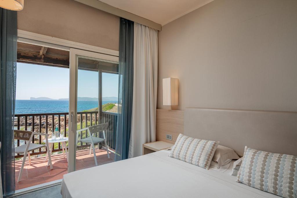 une chambre avec un lit et une vue sur l'océan dans l'établissement Hotel Calabona, à Alghero