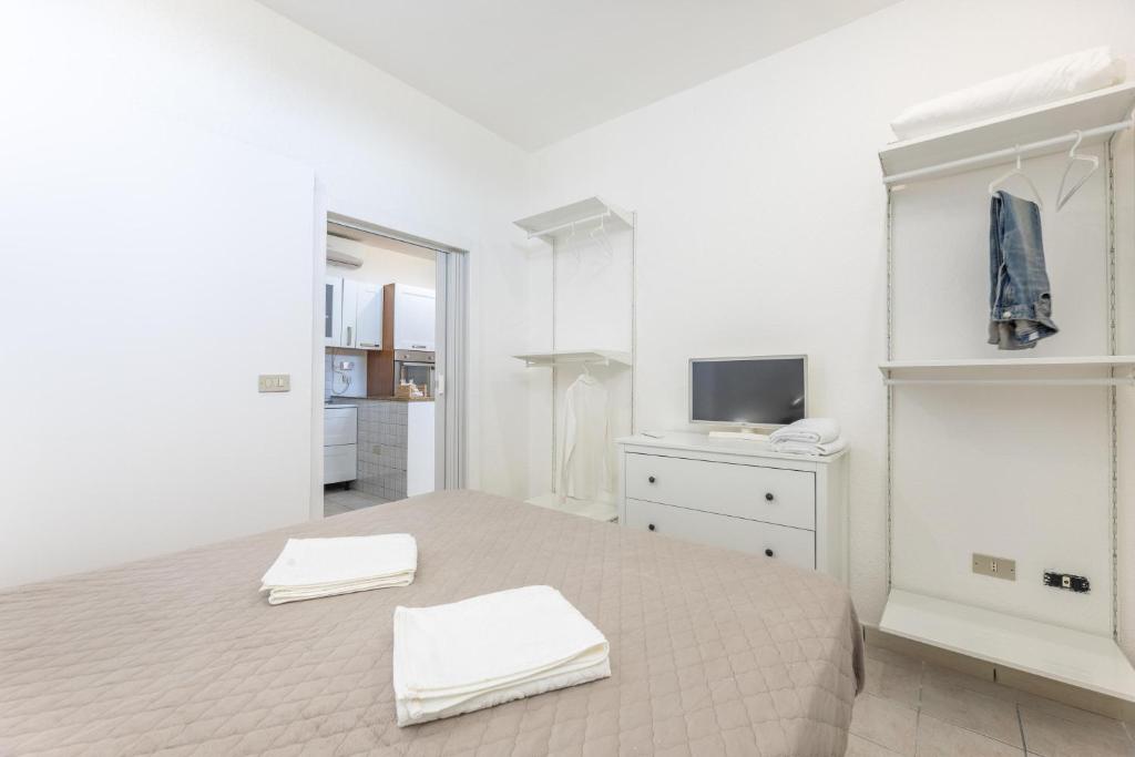 une chambre blanche avec un lit et une télévision dans l'établissement Villa Topazio, à Poggiardo