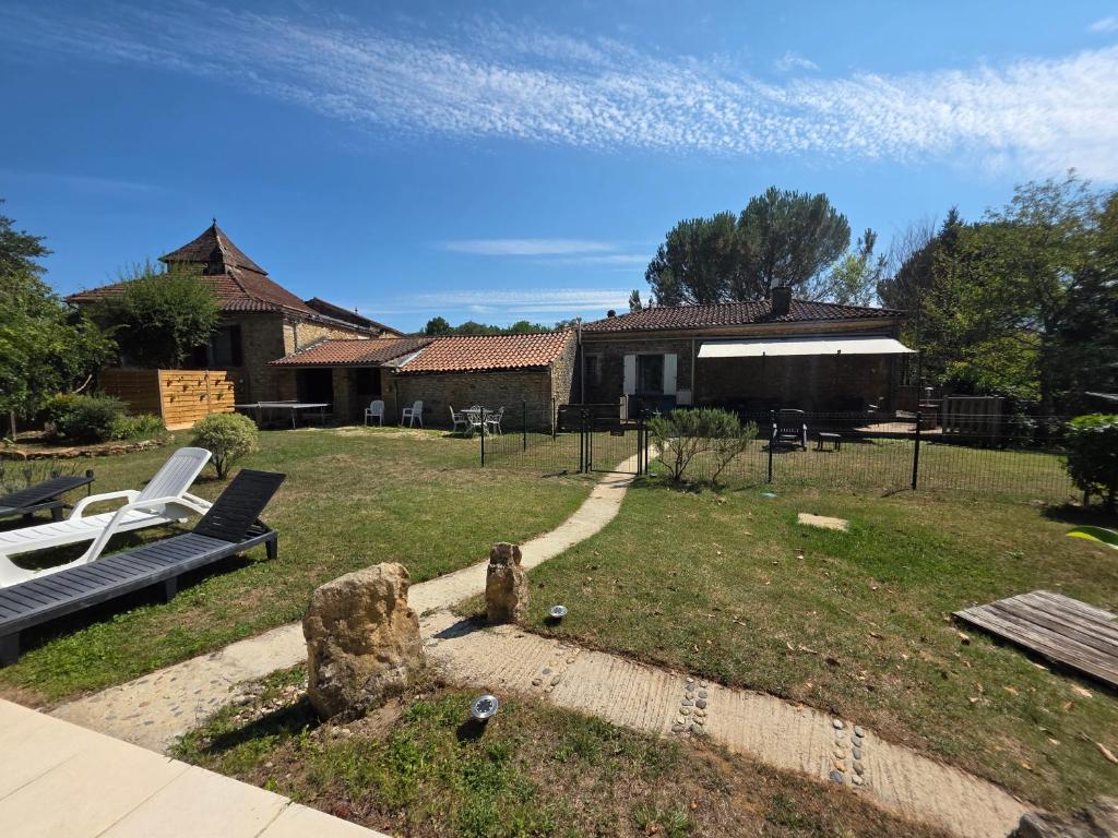 une cour avec un banc et une maison dans l'établissement Gîtes Le Carpe Diem, Cottage Le Petit Pattaris, à Frayssinet-le-Gélat