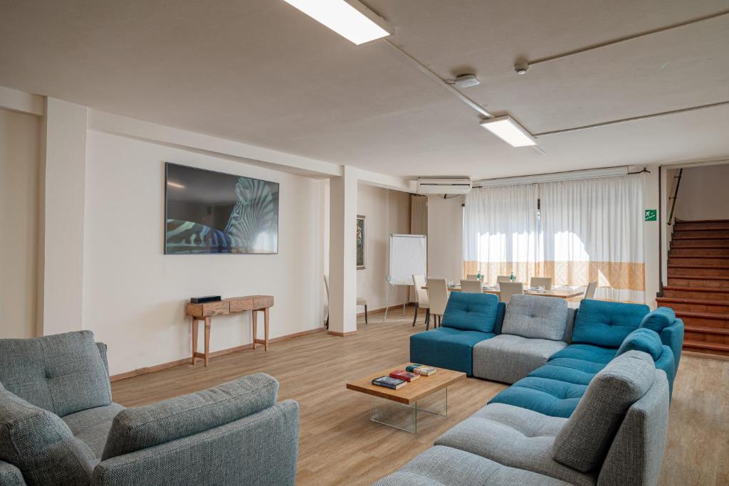 un salon avec deux canapés bleus et une table dans l'établissement Hotel Calabona, à Alghero