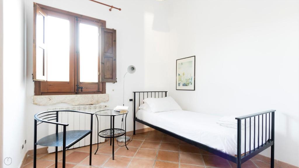 une chambre avec un lit, une table et une fenêtre dans l'établissement Visitsicilia Villa Cialoma, à Scopello