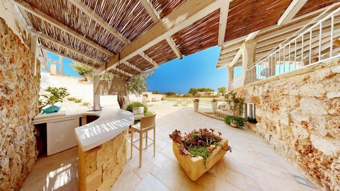 une cuisine extérieure avec un mur en pierre et une table dans l'établissement Muse Salentine, à Santa Maria al Bagno
