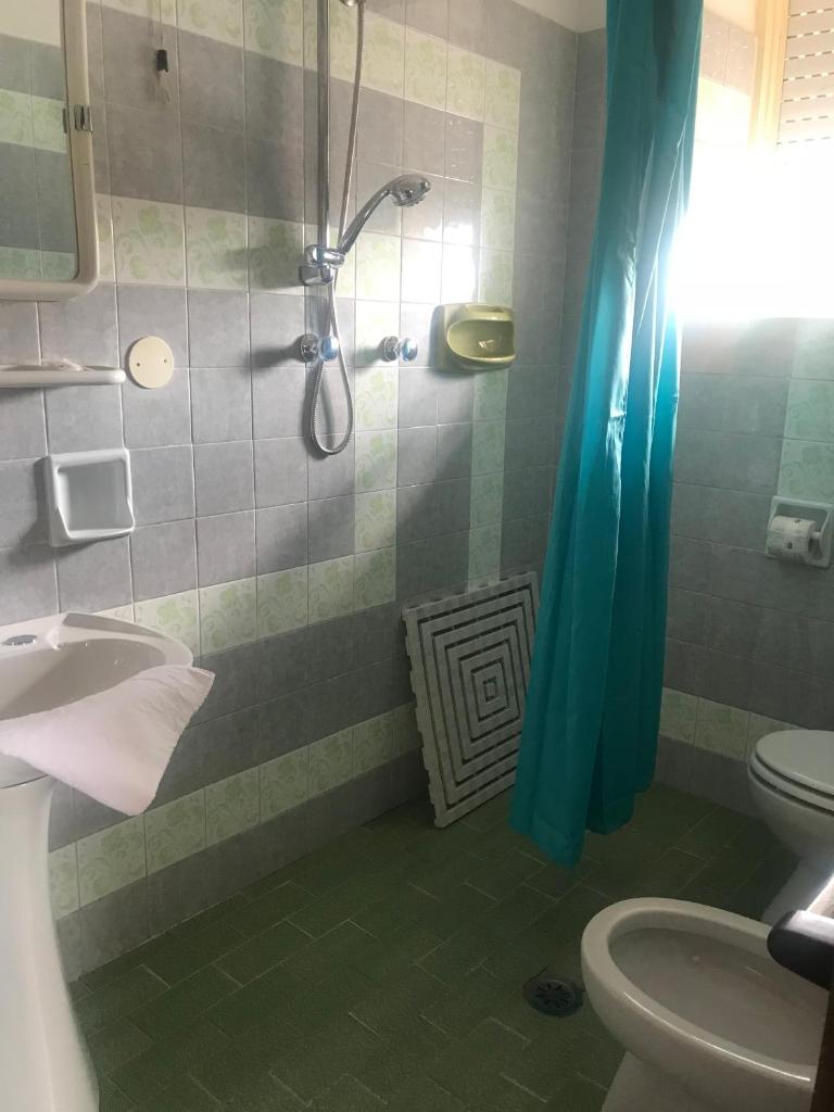 une salle de bain avec une douche avec un lavabo et des toilettes dans l'établissement Cinquestelle Albergo del centro storico, à Palinuro
