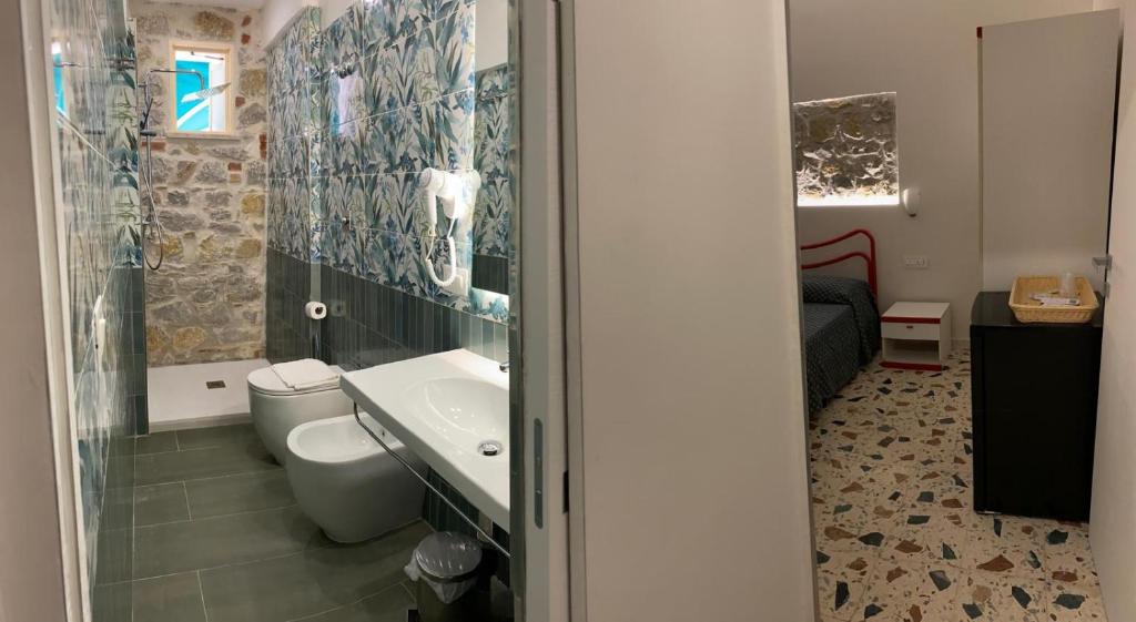 une salle de bain avec toilettes, lavabo et douche dans l'établissement Cinquestelle Albergo del centro storico, à Palinuro