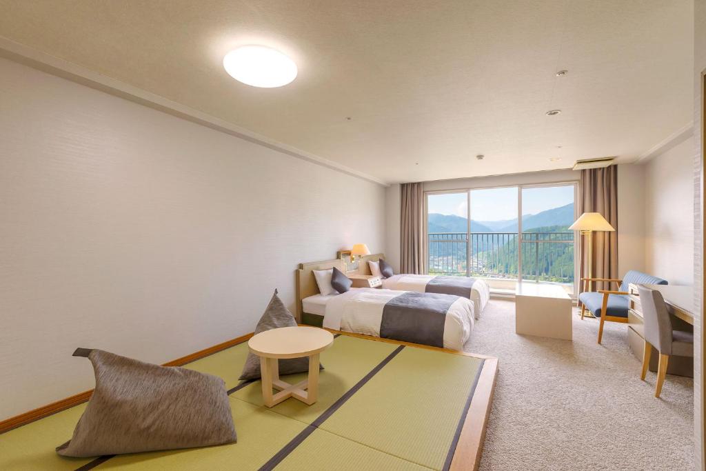 une chambre d'hôtel avec un lit et une grande fenêtre dans l'établissement TAOYA Gero, à Gero