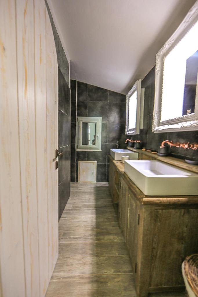 La grande salle de bains est pourvue d'un lavabo et d'une porte. dans l'établissement La Pazienza, à Marina di Gairo