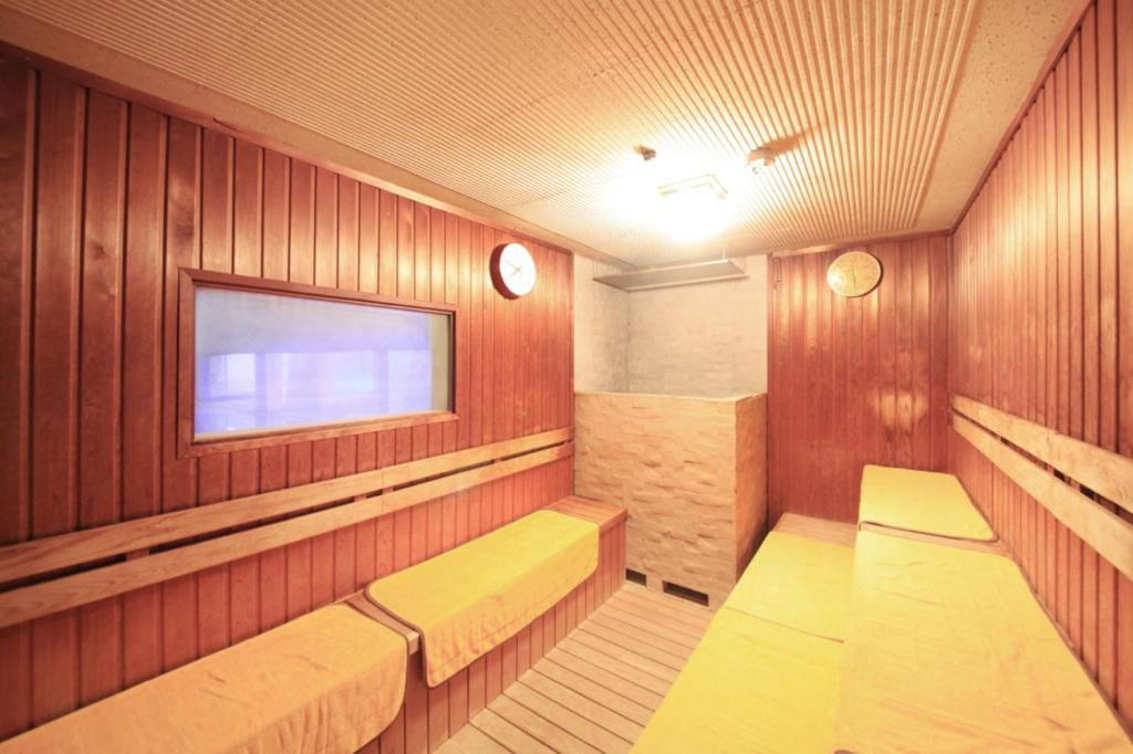 un sauna avec des bancs et une télévision dans une pièce dans l'établissement Hotel Sun Hatoya, à Itō