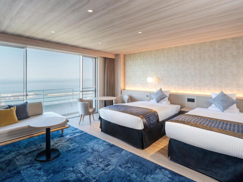 une chambre d'hôtel avec deux lits et un balcon dans l'établissement KAMENOI HOTEL Awajishima, à Awaji