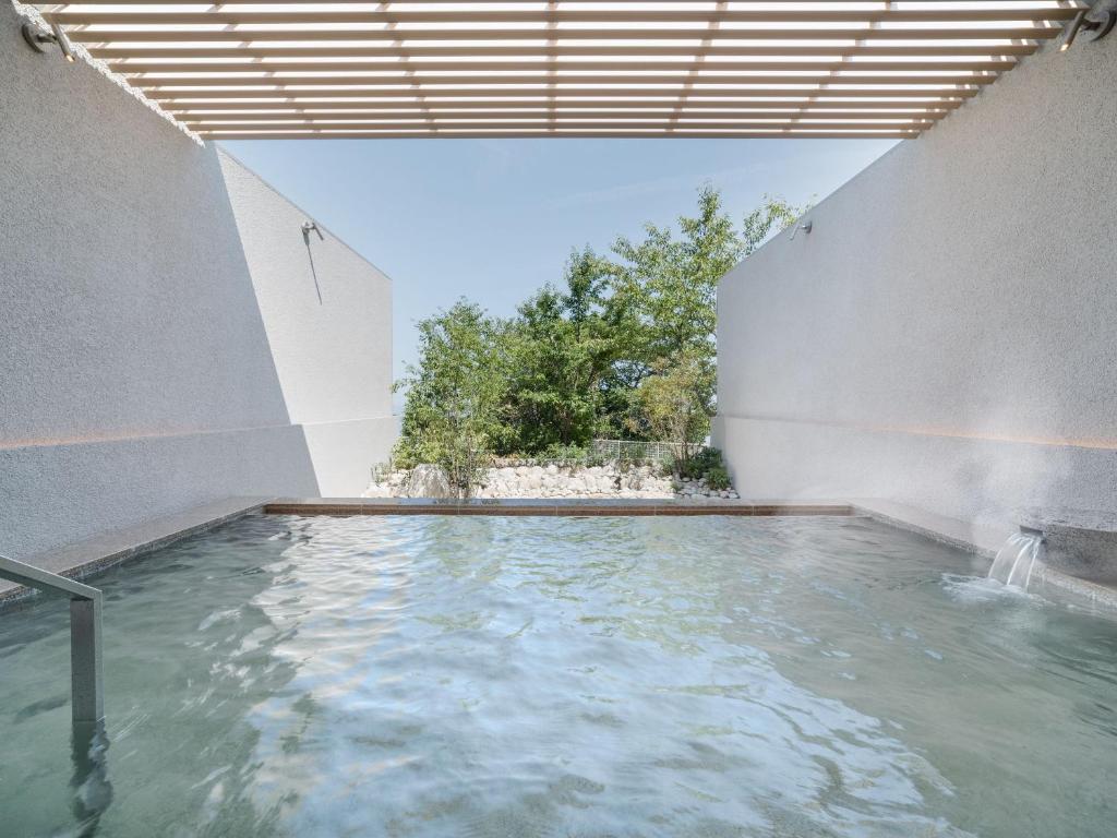 une piscine d'eau à l'intérieur d'un bâtiment dans l'établissement KAMENOI HOTEL Awajishima, à Awaji 90 autres photos
