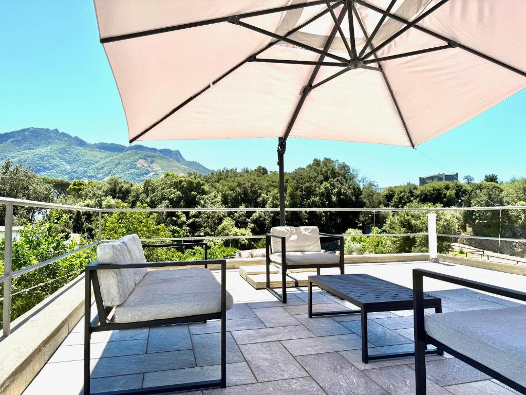 un patio avec deux chaises et un parasol dans l'établissement Rock House Villa, à Ischia
