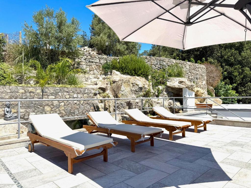 - un ensemble de chaises longues et d'un parasol sur la terrasse dans l'établissement Rock House Villa, à Ischia