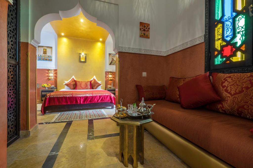 un salon avec un canapé et un lit dans l'établissement Riad Nesma Suites & Spa, à Marrakech 37 autres photos