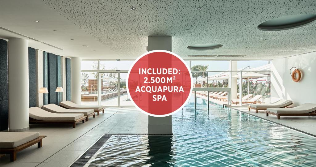 un hall d'hôtel avec un panneau au milieu d'une piscine dans l'établissement Falkensteiner Hotel & Spa Jesolo, à Lido di Jesolo