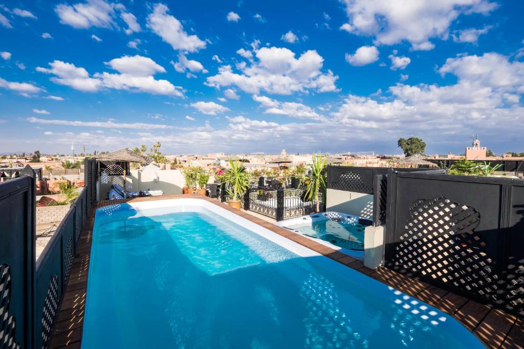 - une piscine sur un balcon avec vue sur la ville dans l'établissement Riad Nesma Suites & Spa, à Marrakech
