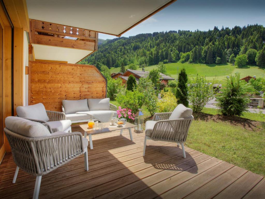 un patio avec deux chaises et une table sur une terrasse dans l'établissement Chalet Edenalpa - OVO Network, à La Clusaz