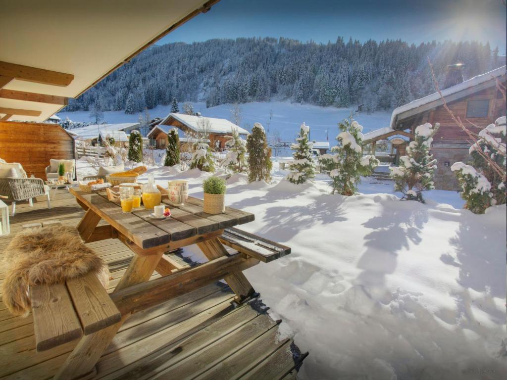 une terrasse avec une table de pique-nique dans la neige dans l'établissement Chalet Edenalpa - OVO Network, à La Clusaz