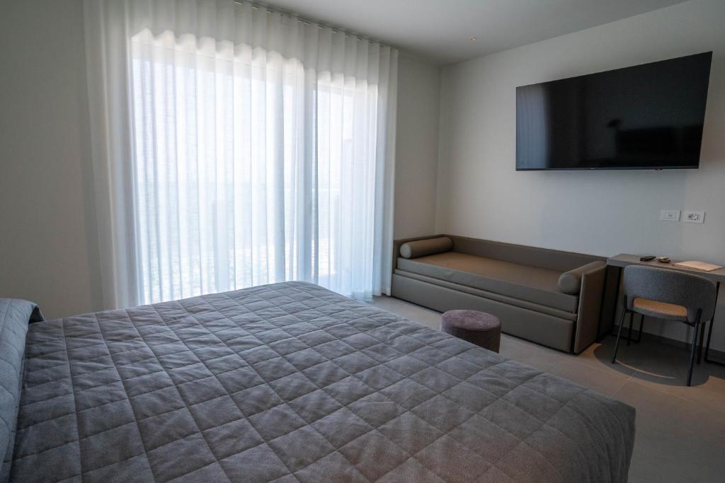 une chambre avec un lit, un canapé et une télévision dans l'établissement Hotel Il Caminetto, à Porto San Giorgio 14 autres photos
