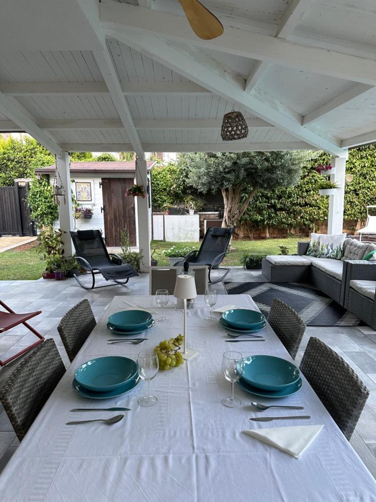 une table blanche avec des assiettes et des verres à vin sur une terrasse dans l'établissement Villa sole Sicily, à Terrasini